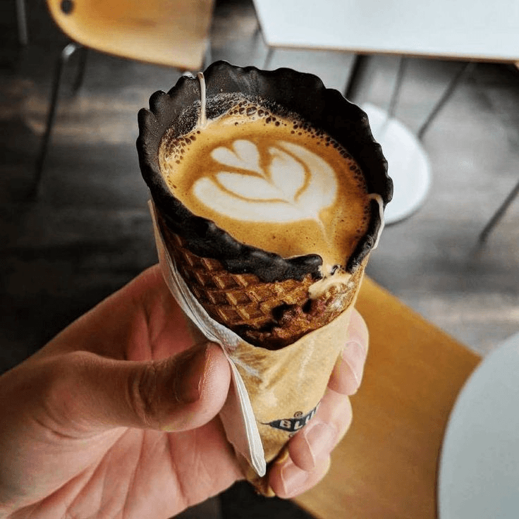 Coffee in a waffle cone cup with latte art